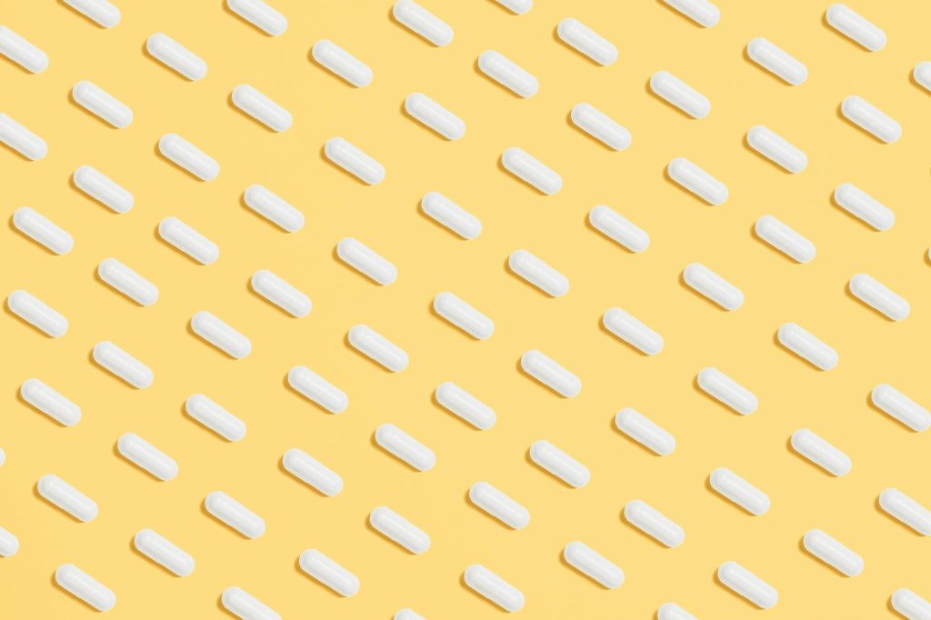 white capsules on yellow background