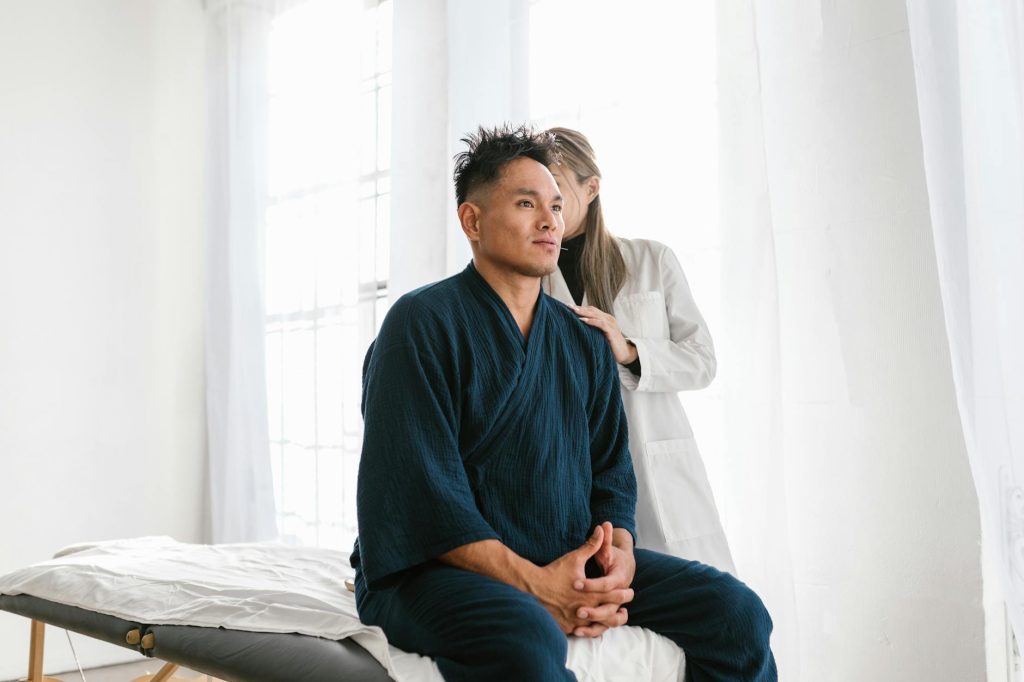 patient sitting and doctor standing behind