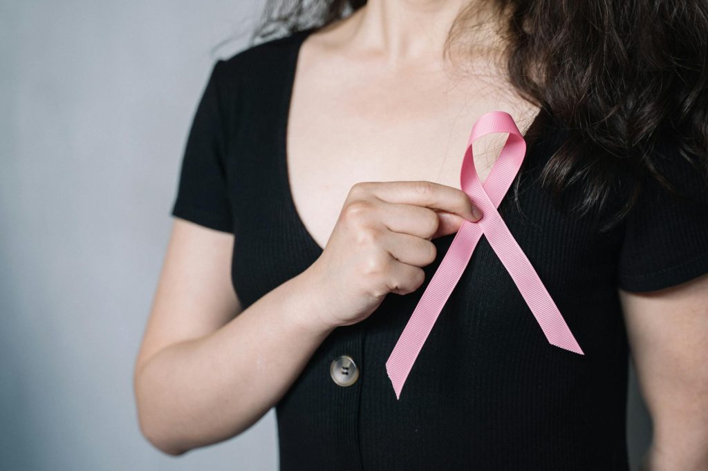 woman holding pink ribbon