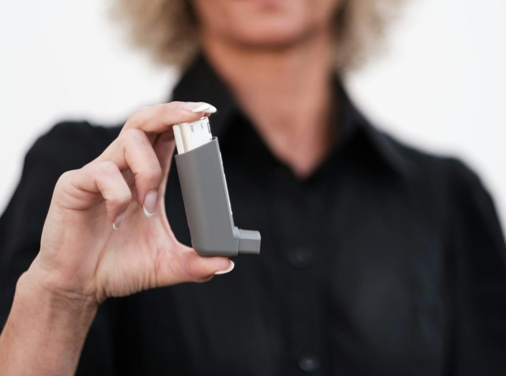 woman holding asthma inhaler for respiratory relief